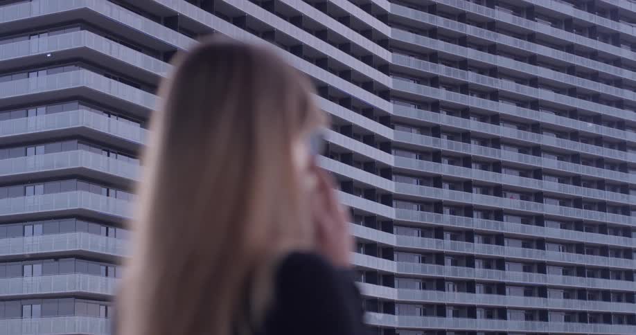 A woman uses a phone on the balcony