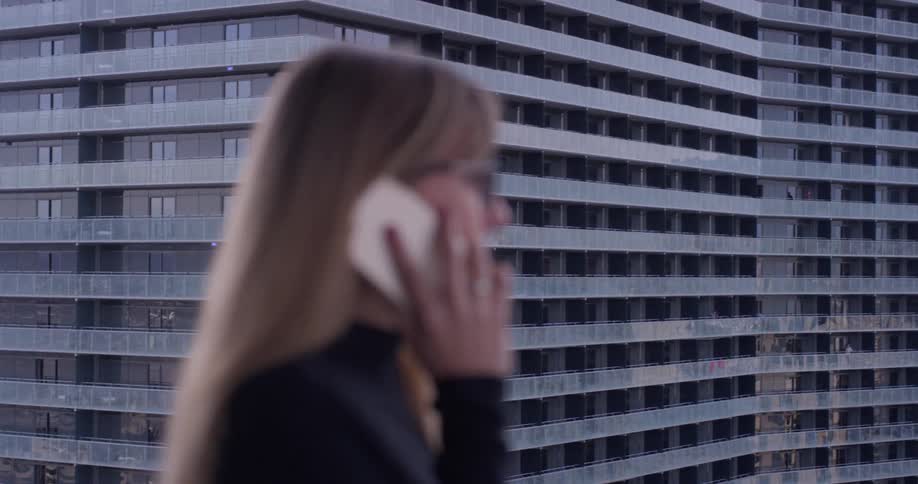 A woman uses a phone on the balcony