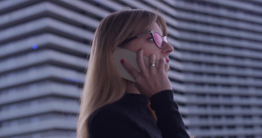 A woman uses a phone on the balcony
