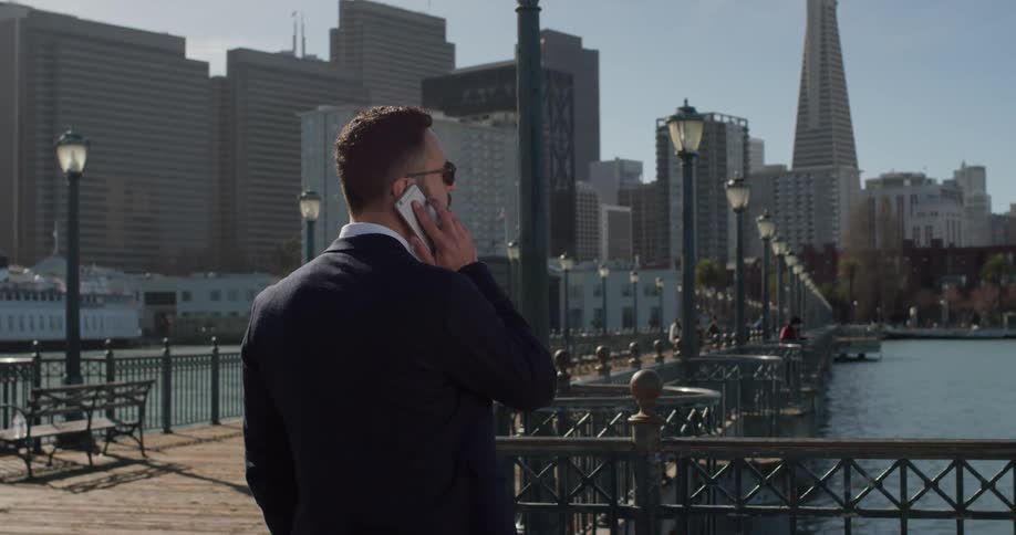 A man in a suit uses his phone outside