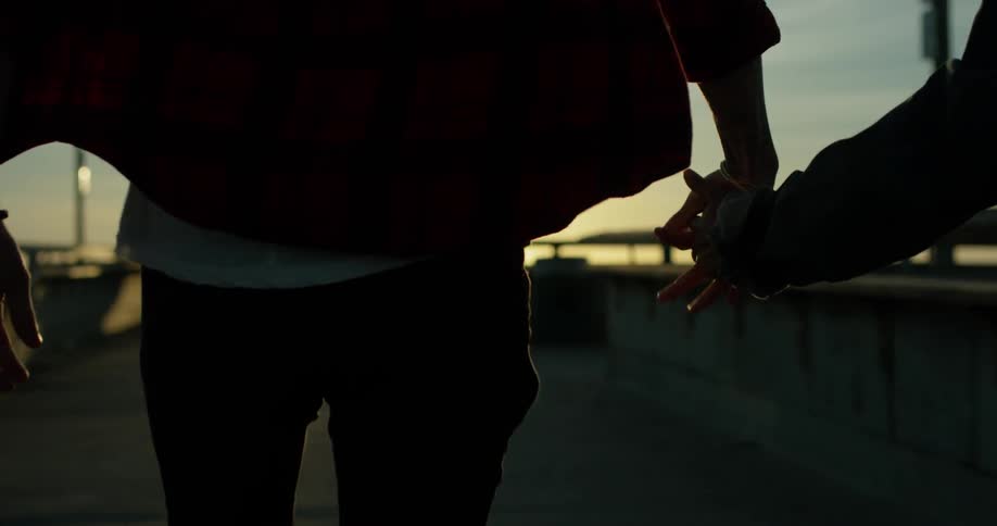 A man and woman hold hands as they walk