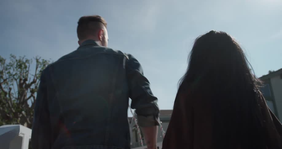 A man and woman hug outside as they walk