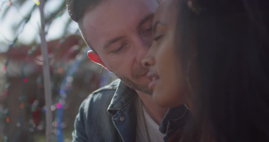 A man and woman kiss outside