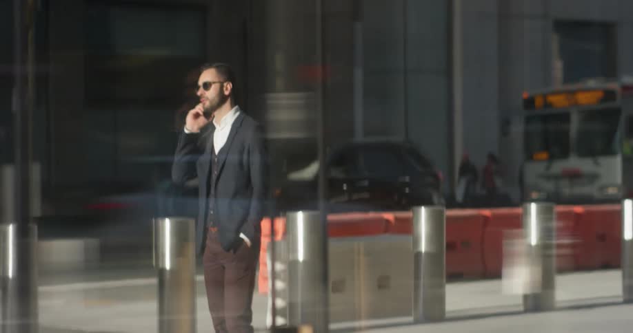 A man in a suit uses his phone outside