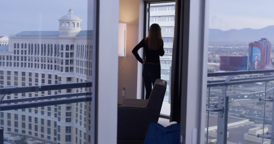 A woman talks on the phone inside her apartment