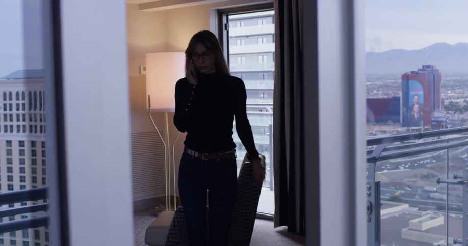 A woman uses a phone inside the apartment