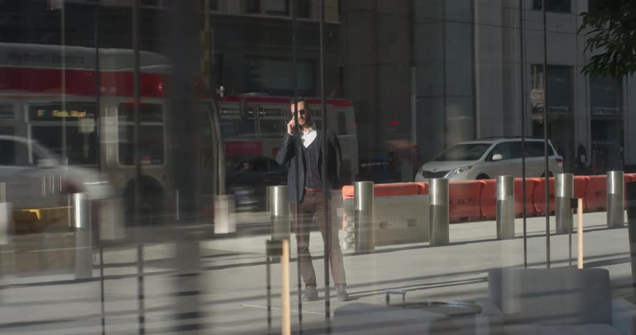 A man in a suit uses his phone outside