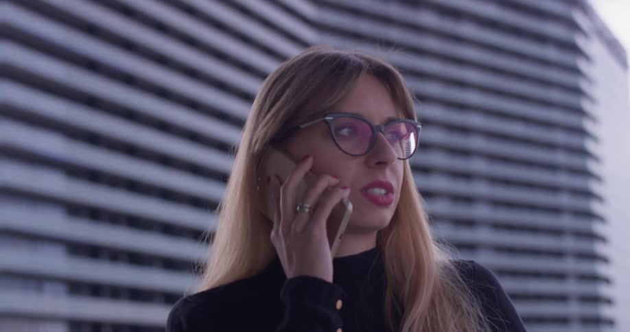 A woman uses a phone on the balcony