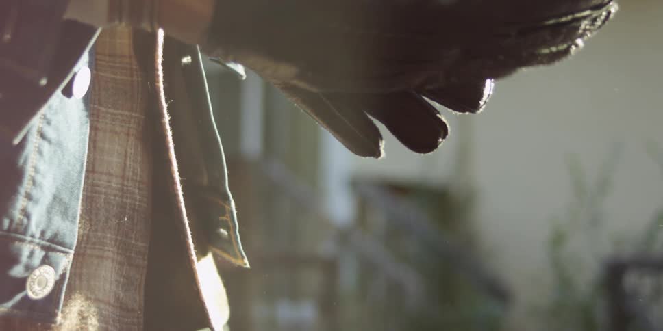 A motorcyclist puts on a leather glove