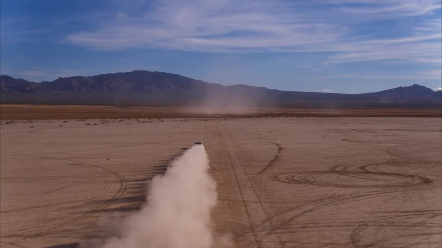 A car speeds off over the open land