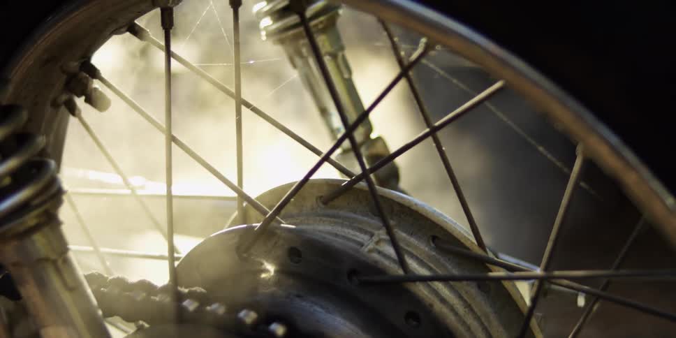 Smoke billows around a motorcycle wheel
