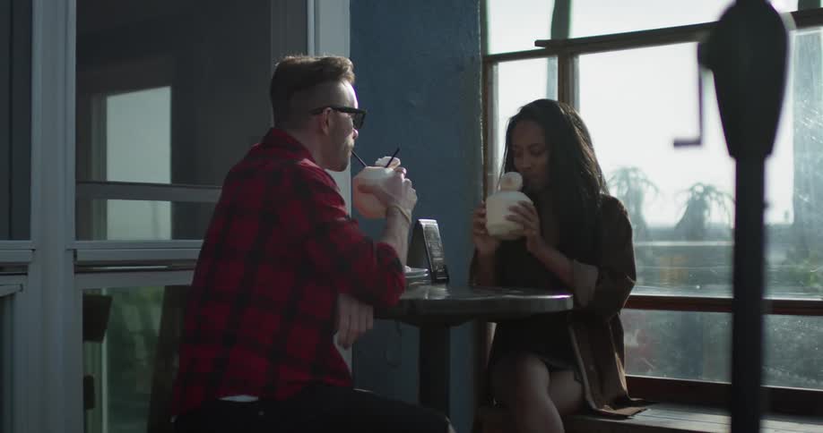 A man and woman toast with coconut drinks
