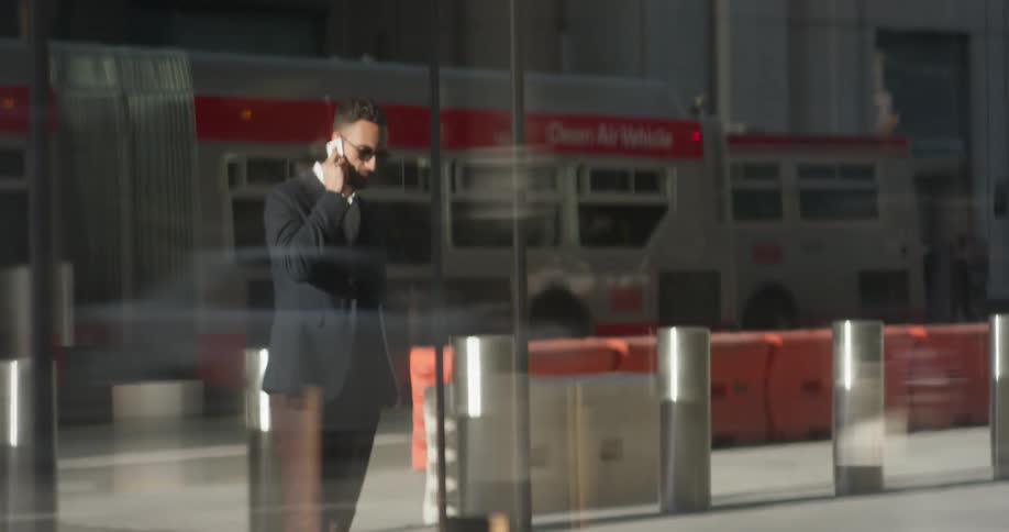 A man in a suit uses his phone outside