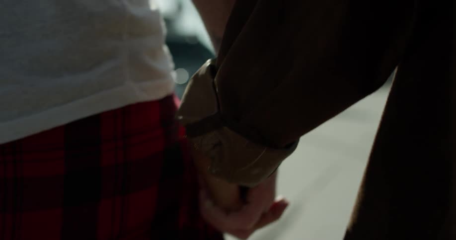A man and woman hold hands as they walk