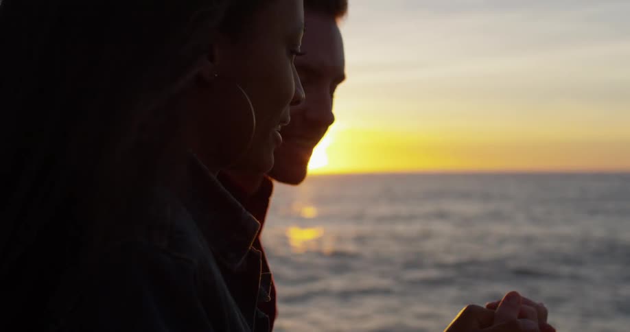 A man and woman hold hands together on the beach