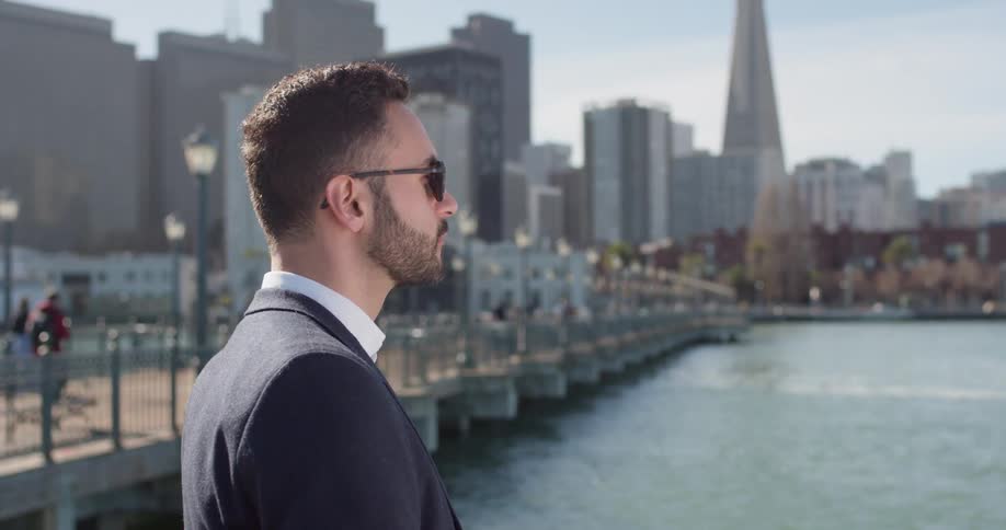 Man wearing sunglasses looks out at the lake
