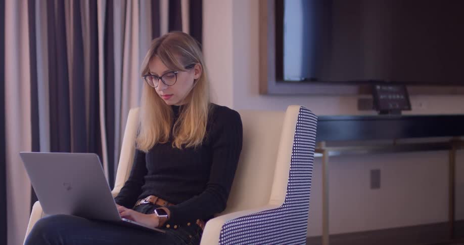 A woman uses a laptop in the chair