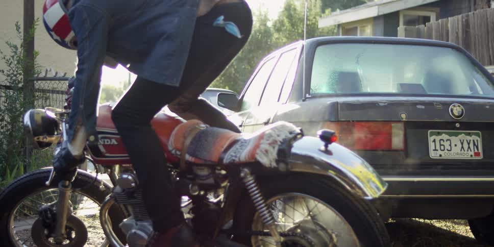 A man climbs onto a motorcycle