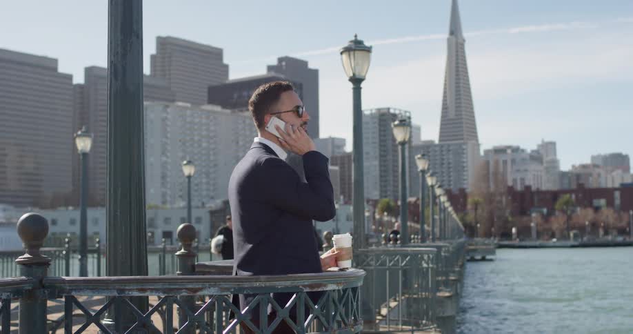 A man uses his phone on the city pier