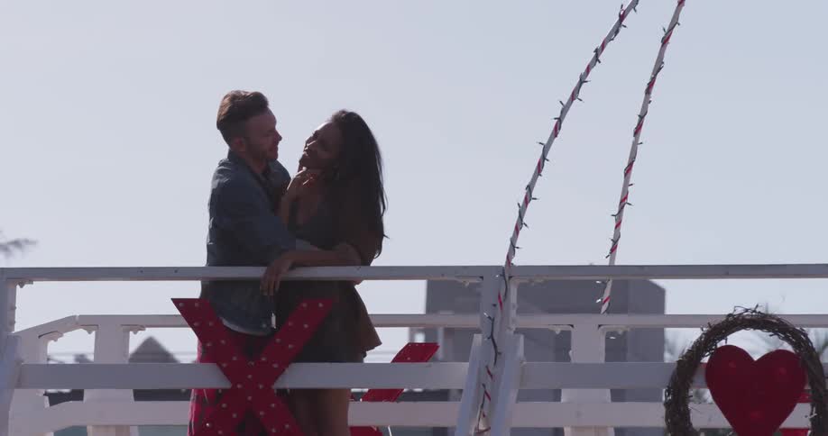 Man and woman embrace on pier