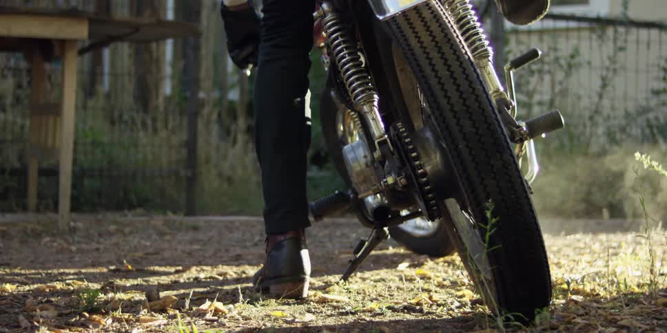 Person sitting on and starting a motorcycle