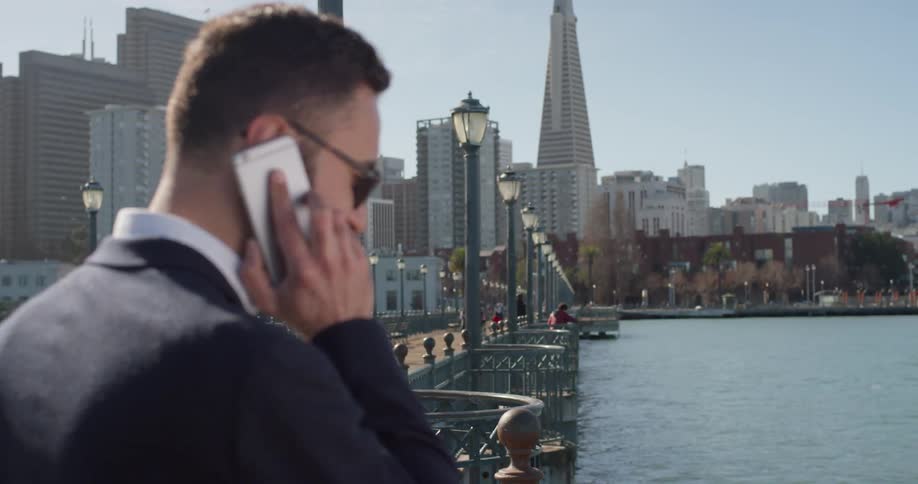 A man uses his phone at the city pier