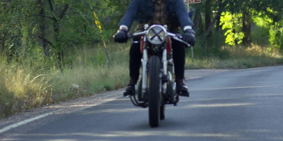 Man riding a motorcycle down a country road