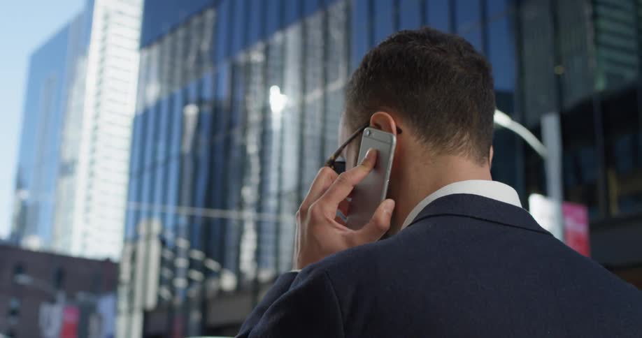 A man in a suit uses his phone outside