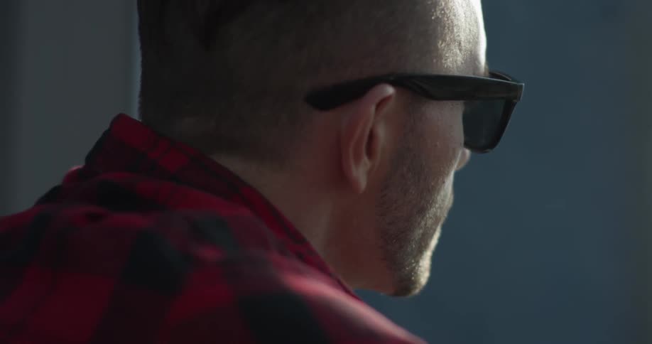 A man in sunglasses nods his head