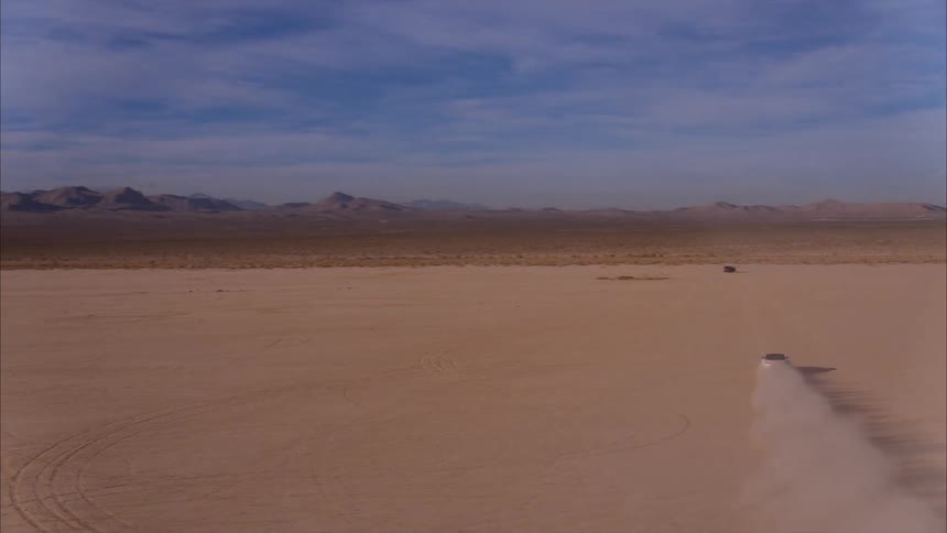 Truck drives across the wide flat desert