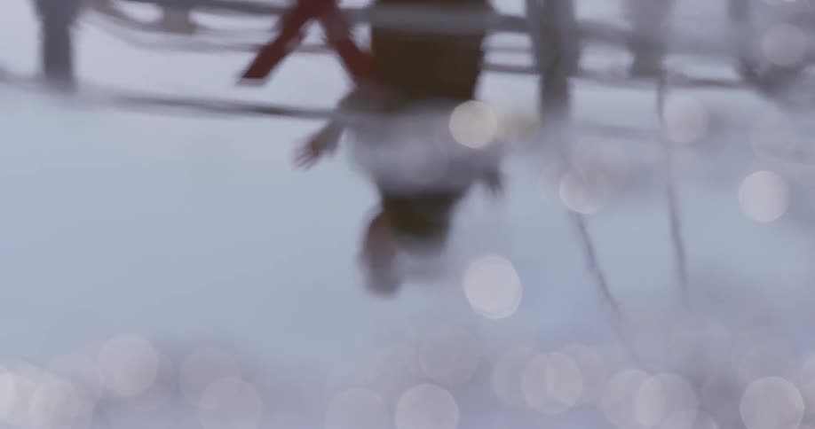 Man and woman hug as they stand near the water
