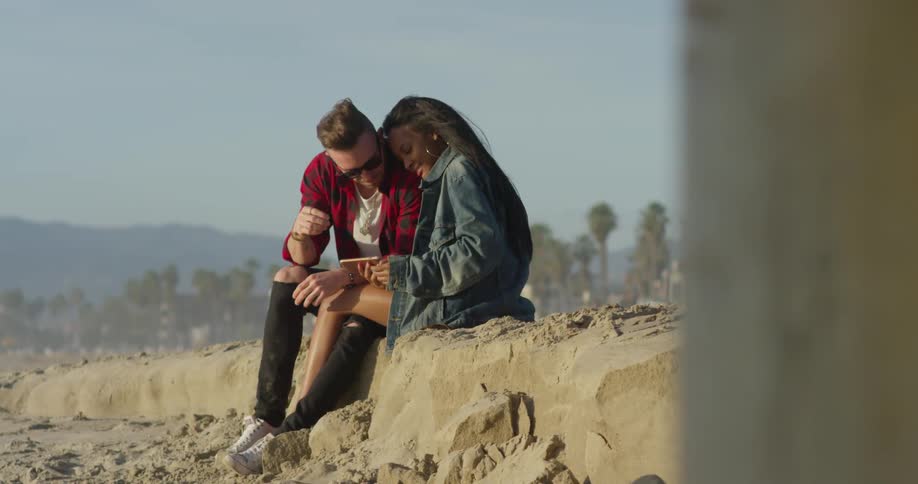Man and woman sit on a beach