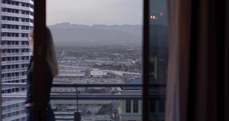 Woman walks on balcony as she talks on a cellphone