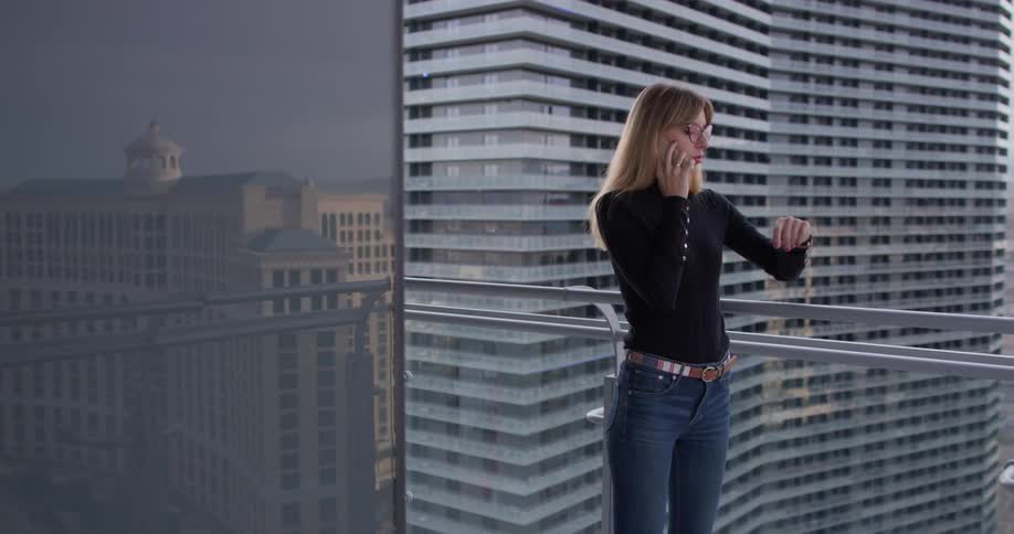 A woman uses a phone on the balcony