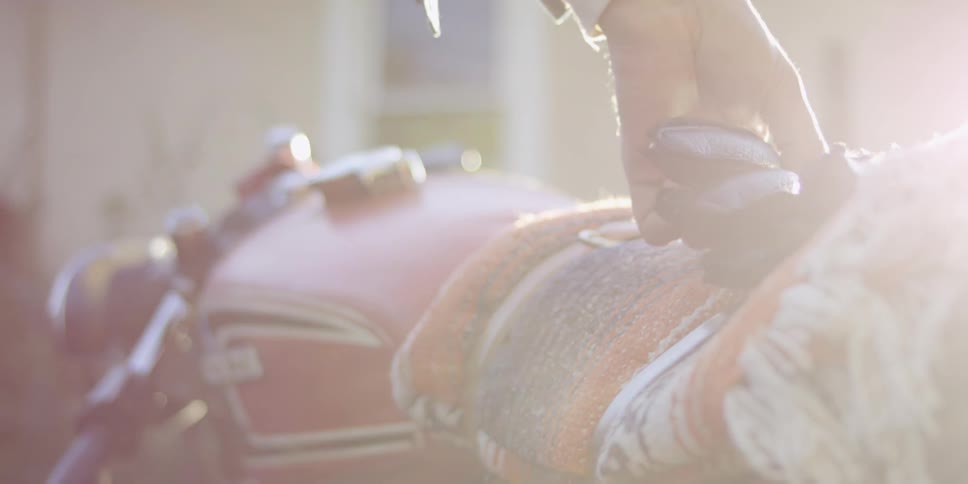 Close up of a hand taking gloves off a motorcycle