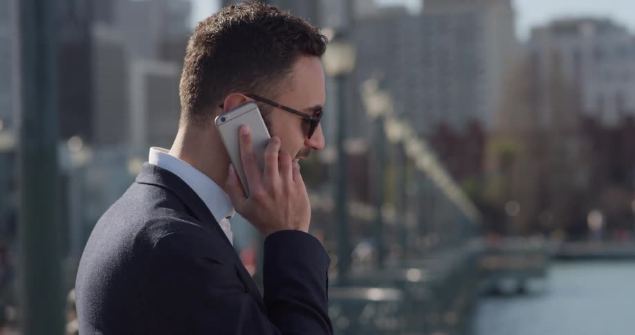 A man in a suit uses his phone outside