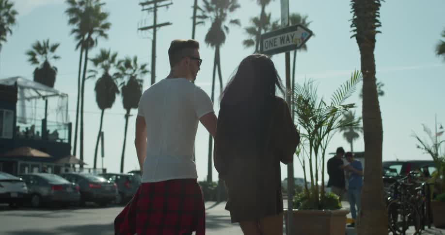 A man and woman hold hands as they walk