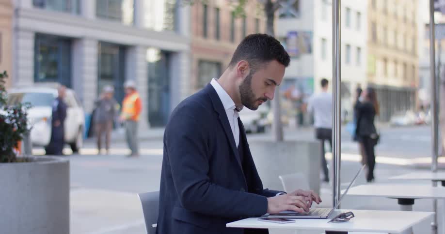 A business man uses his laptop outside