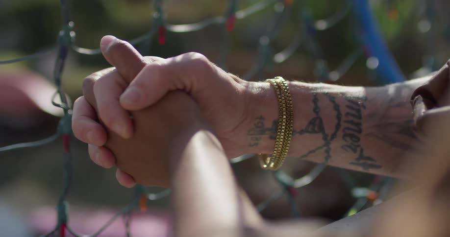 A man and woman hold hands outside