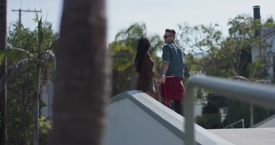 A man and woman hug and hold hands outside
