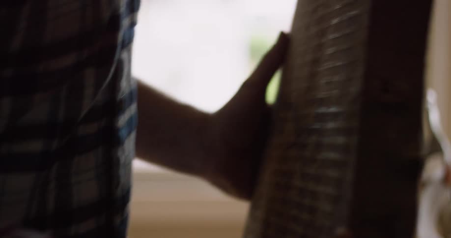 A man lifts a large piece of wood