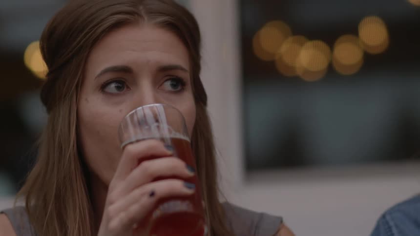 Woman with dark nail polish takes a drink