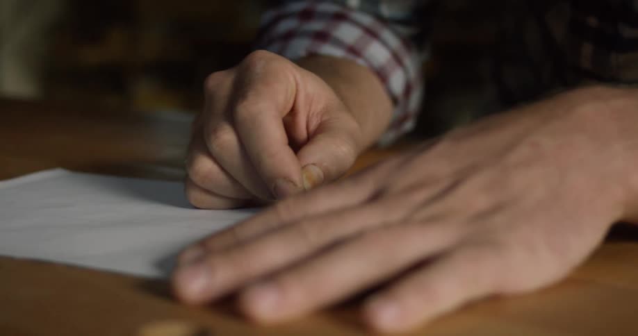 Man drawing with a pencil at a table