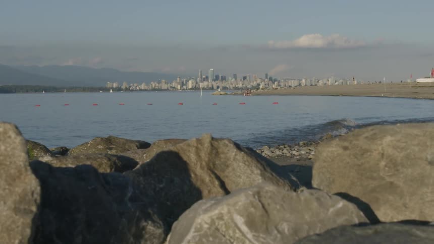 A rocky coastline near a city