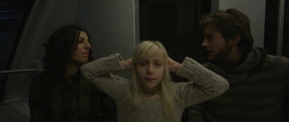 Riding on a subway car, a young couple argues while a young woman stares into the camera and puts her hands behind her head