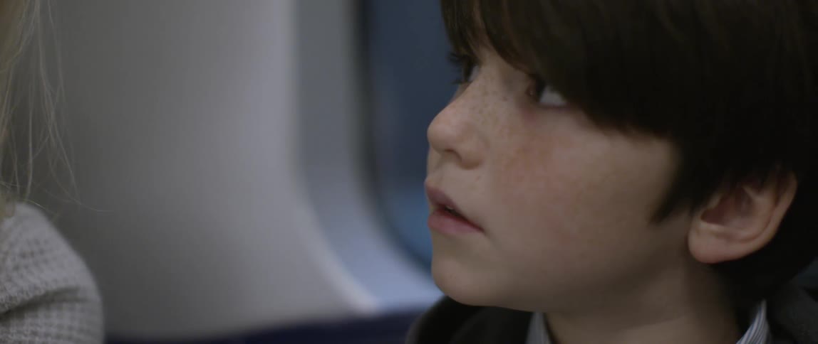 A young boy with freckles on the subway
