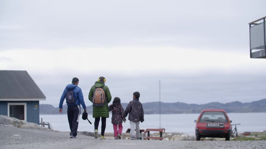 A family walks towards a lake