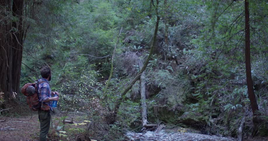 A hiker grabs a water bottle from his bag