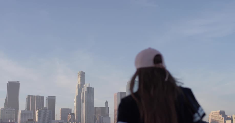 A woman in a pink hat walks on the building rooftop