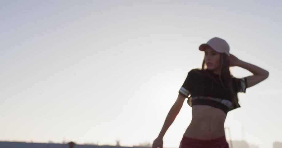 A woman in a pink hat dances outside